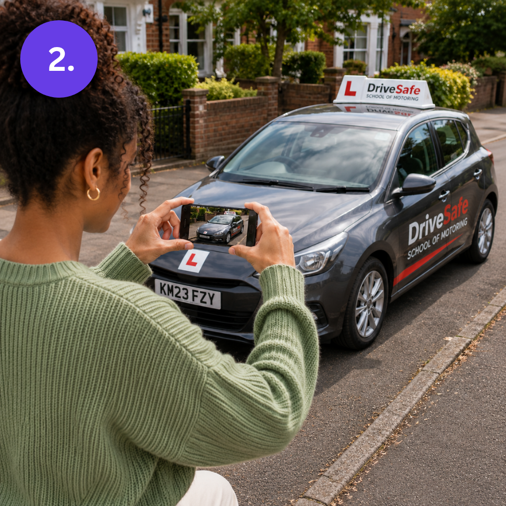 Woman photographing a black driving instructor car with L-plates and a roof sign on her phone, ready to create her listing
