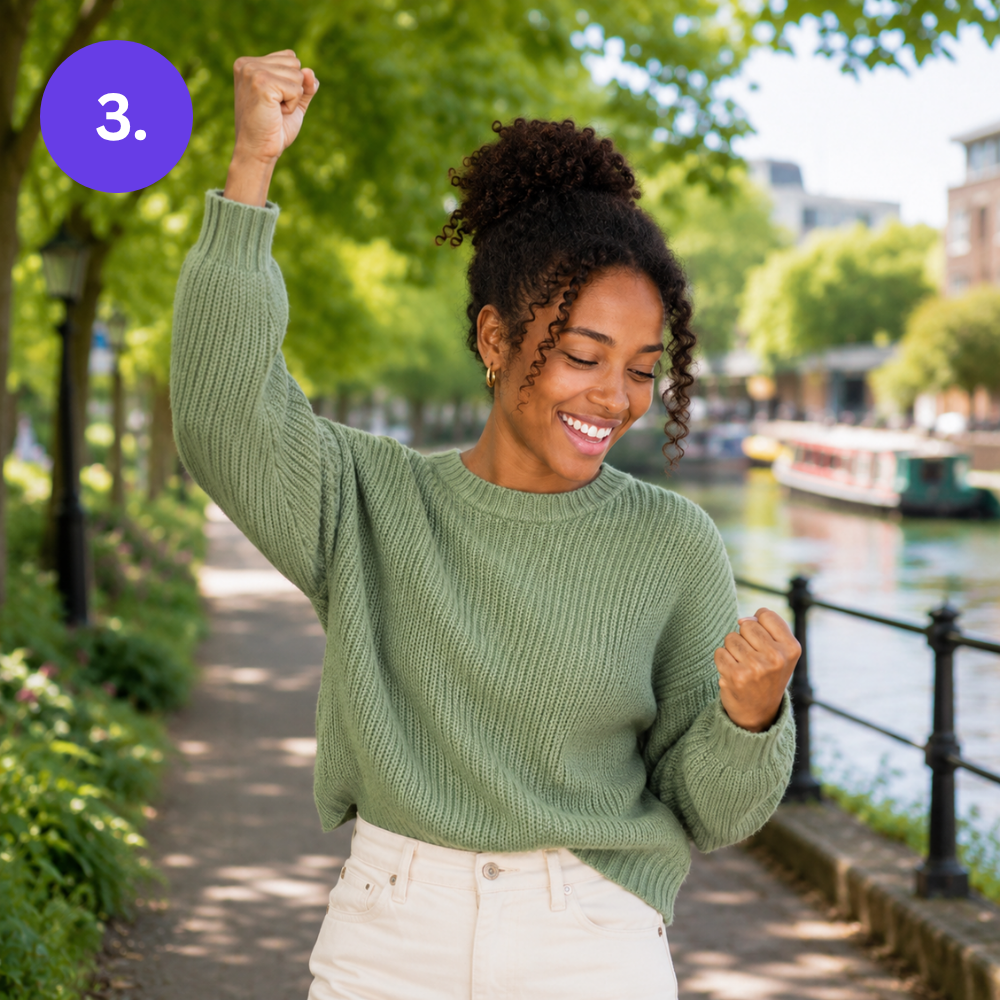Woman raising a fist in celebration while walking outdoors, having successfully sold her driving instructor car